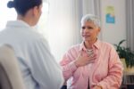 A woman at the doctor after experiencing irregular heartbeat symptoms.