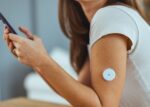 A woman without diabetes is wearing a glucose monitor.