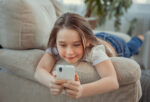 A child using her smartphone, which causes mental health concerns.