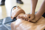 A person performing CPR according to updated guidelines.