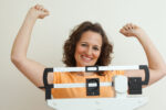 A woman celebrating weight loss with the help of glp-1 medication.