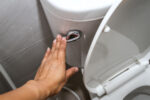 A woman flushes the toilet after experiencing a change in stool, a warning sign of colorectal cancer.